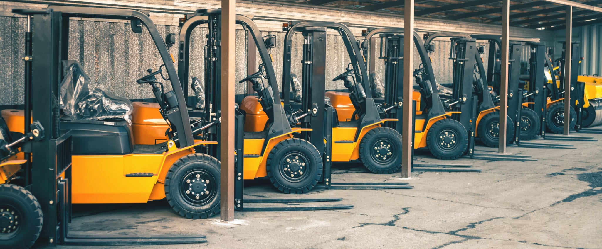 A row of parked fork lifts.